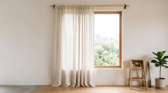 Interieur lumineux avec une tringle a rideaux parfaitement fixee au-dessus d'une fenetre encadree de rideaux amples